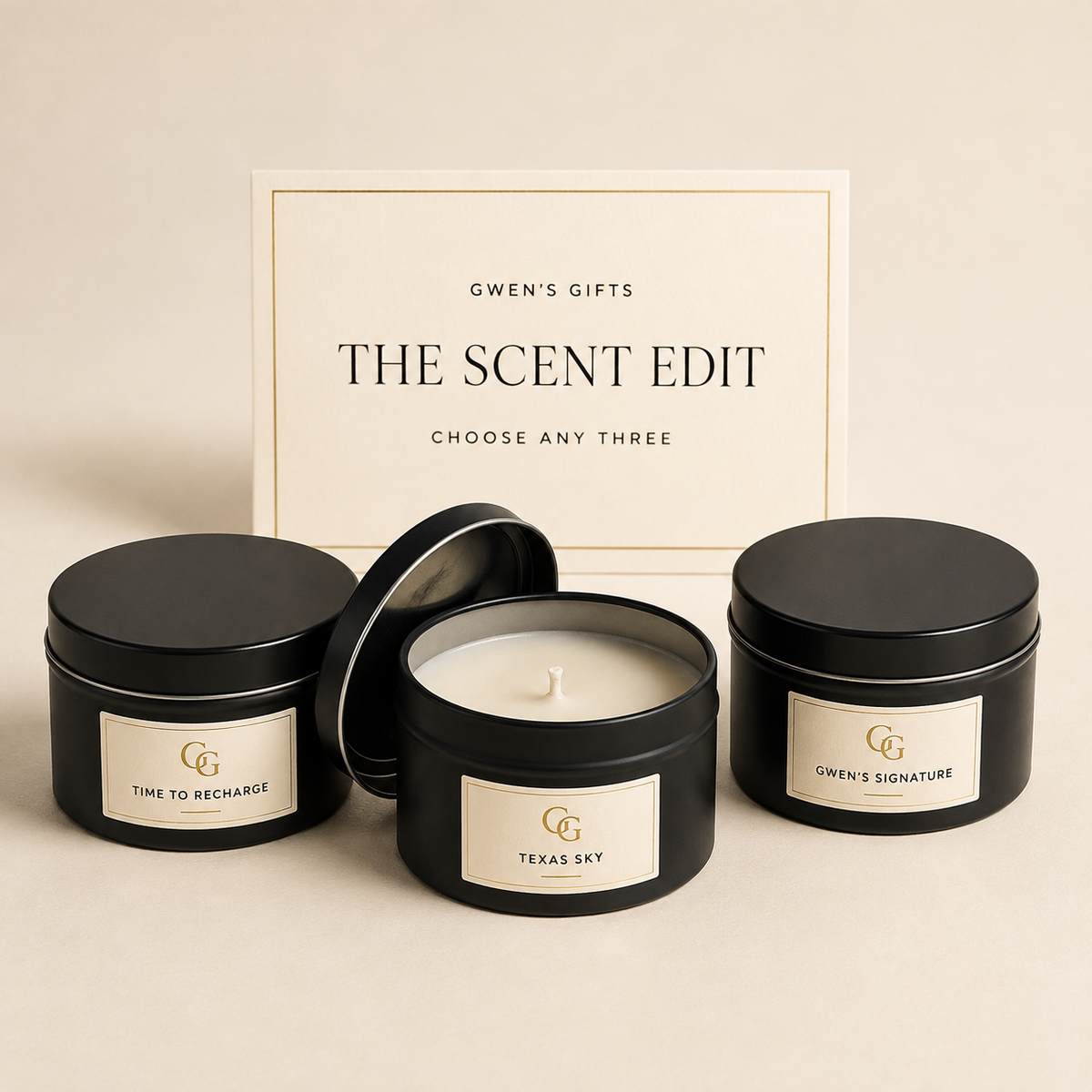 Three travel candles in matte black tins in front of a Gwen's Gifts Scent Edit card
